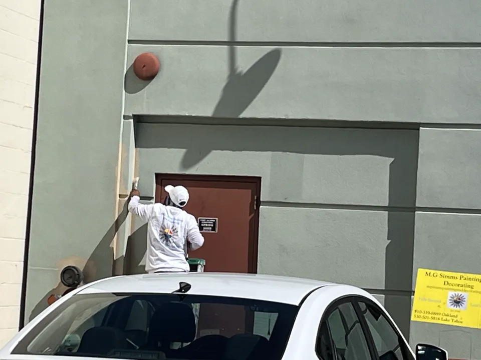 M.G. Simms crew painting a set of commercial doors on a job site.