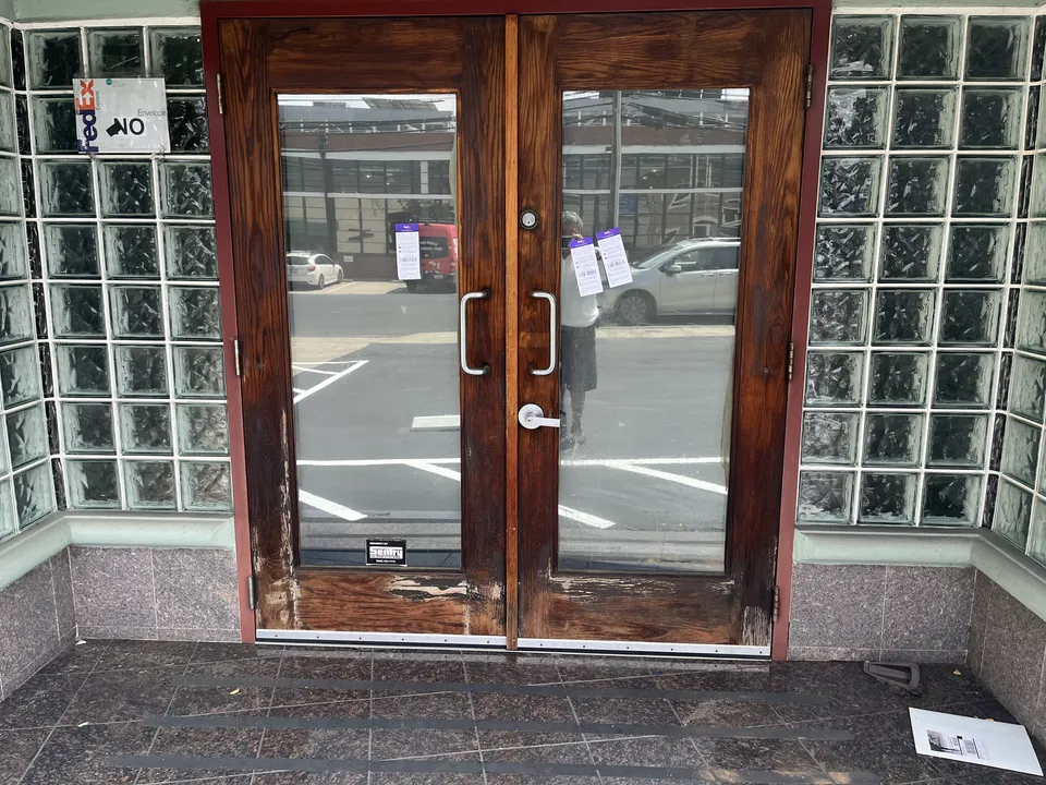 Commercial storefront with repainted entry doors and metal frames.
