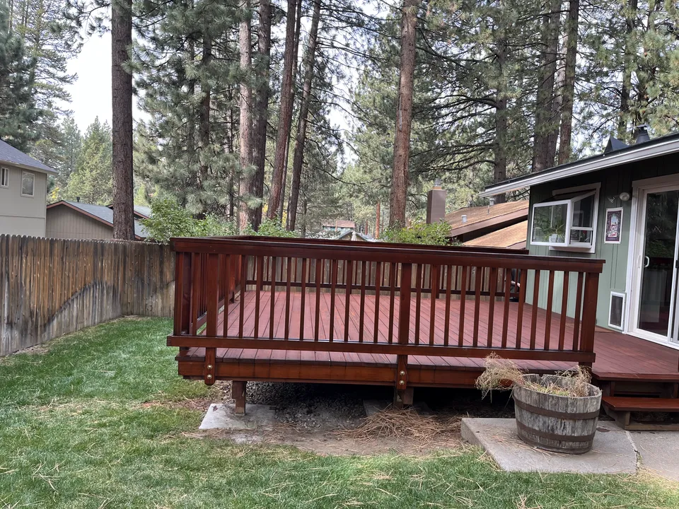Large backyard deck after sanding and staining, boards even and warm in tone.