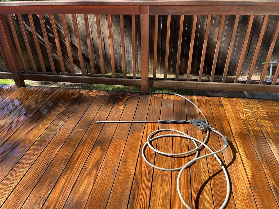 Close-up of a sanded and re-stained deck railing showing clean, even grain.