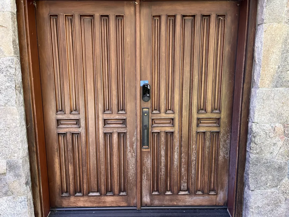 Carved wooden entry door stripped and refinished to a rich warm tone.