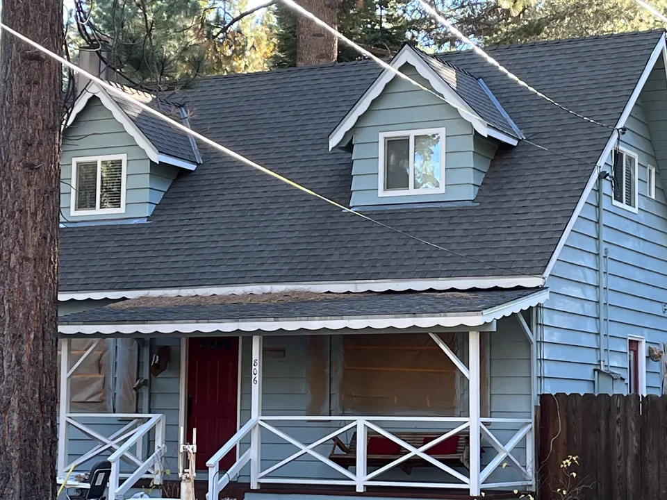 Blue cottage-style house with a freshly painted front porch and white railings.