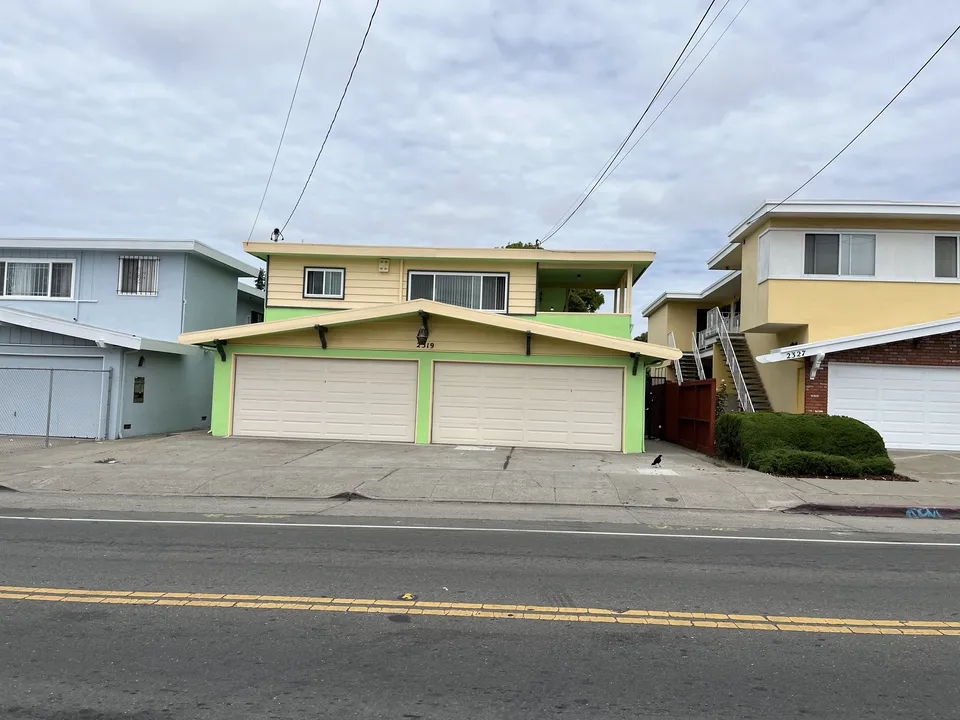 Two-unit duplex after an exterior repaint with contrasting trim colors.
