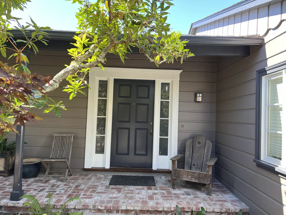 House with new gray siding paint and a contrasting repainted entry door.