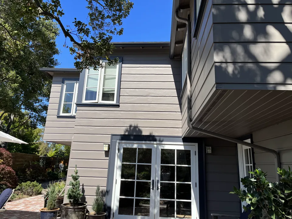 Exterior French doors with freshly painted frames and surrounding trim detail.