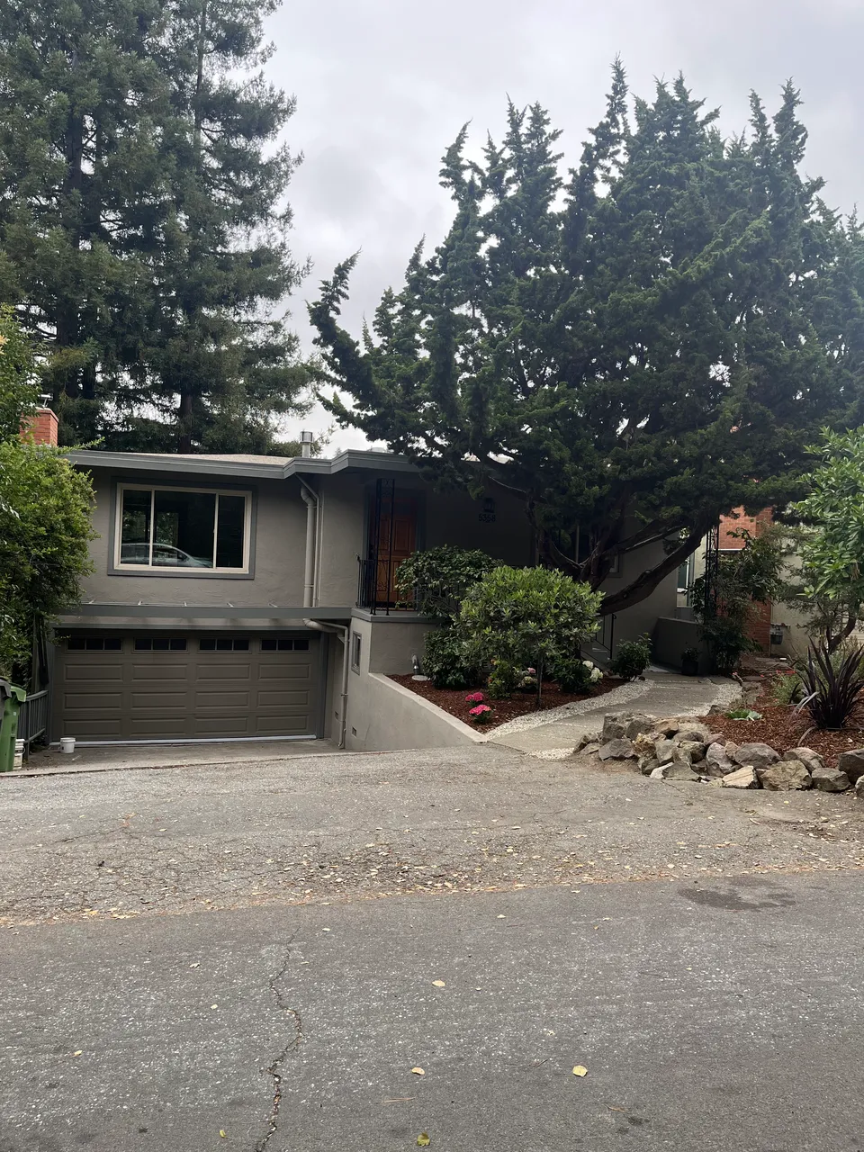 A completed exterior painting job seen from the driveway.